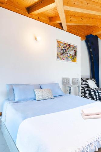 a bedroom with a white bed and a wooden ceiling at Panoramic refuge 5-Baita Lago Blu in Bellano