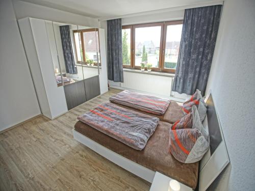 a bedroom with two beds and a large window at Ground-floor apartment with terrace and large garden with lounge area and grill in Mönkebude
