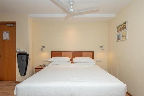 a bedroom with a white bed with a ceiling fan at Best Western Nairobi Upper Hill in Nairobi