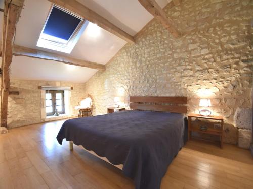a bedroom with a bed and a stone wall at Holiday home with pool in Verteillac in Verteillac