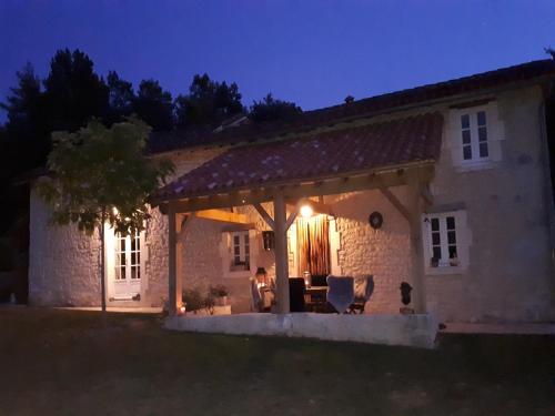 a stone house with a patio at night at Holiday home with pool in Verteillac in Verteillac