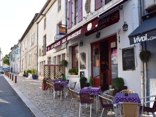 an outdoor cafe with purple tables and chairs on a street at Holiday home with pool in Verteillac in Verteillac