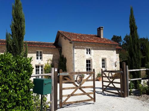 an old house with a gate and a building at Holiday home with pool in Verteillac in Verteillac