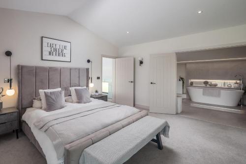 a large bedroom with a large bed and a bath tub at 7 Bed in Marwood oc-w32673 in Marwood