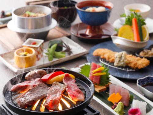 a table with plates of food on a table at KAMENOI HOTEL Nachi Katsuura Kumano Kodo in Nachikatsuura