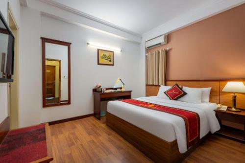 a hotel room with a large bed and a mirror at Regal Hotel Hà Nội in Hanoi