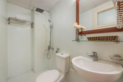 a bathroom with a toilet and a sink and a mirror at Regal Hotel Hà Nội in Hanoi