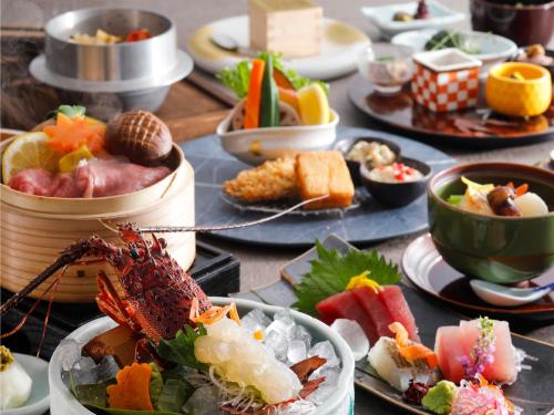 a table topped with plates of food with a lobster at KAMENOI HOTEL Nachi Katsuura Kumano Kodo in Nachikatsuura