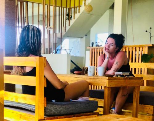 two women sitting at a table in a restaurant at Wake N Flow, Weligama in Weligama