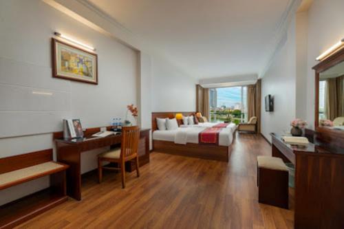 a hotel room with a bed and a desk and a desk at Regal Hotel Hà Nội in Hanoi