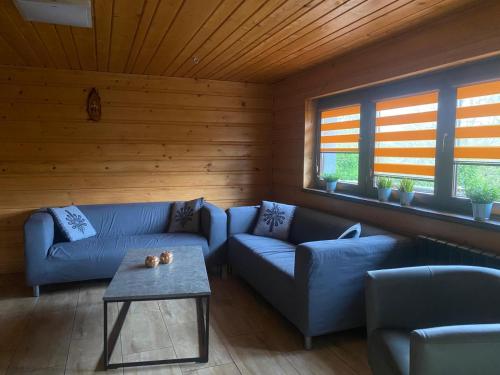 a living room with blue couches and a table at Chatka Puchatka in Tenczyn
