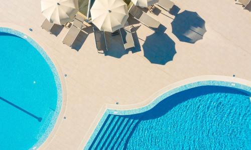 an overhead view of a beach with umbrellas and a swimming pool at Marko Polo Maradiso Hotel by Aminess in Korčula