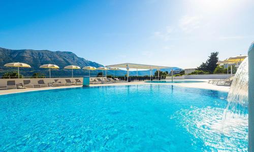 a large swimming pool with a water fountain at Marko Polo Maradiso Hotel by Aminess in Korčula