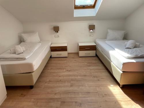 two twin beds in a room with a window at Apartments Garden House in Niedernsill
