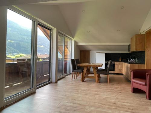 a kitchen and dining room with a table and chairs at Apartments Garden House in Niedernsill
