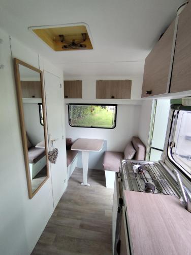 a small kitchen and dining area of a caravan at Friendly Camping and Lodges in Saint-Pardoux-la-Rivière