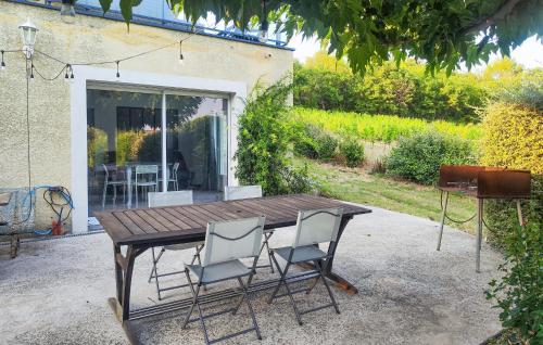 une table en bois et quatre chaises dans une cour dans l'établissement Appt Avec Jardin Prive, à Lieuran-Cabrières