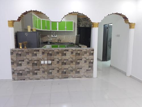 a kitchen with a brick counter with a laptop on it at شقة مفروشه بالمجاردة 2 in Al Majaridah