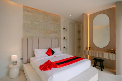 a bedroom with a white bed with a red bow on it at SOOJIWA VILLA by Taman Bali in Dalung