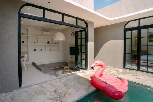 a swimming pool with a pink inflatable flamingo in a house at SOOJIWA VILLA by Taman Bali in Dalung