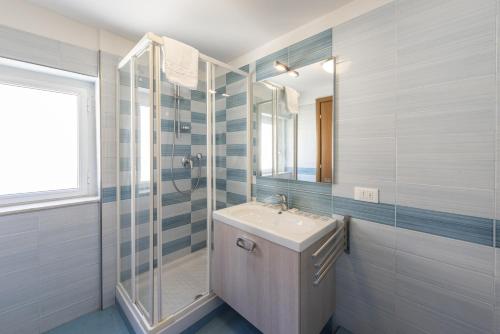 Un baño blanco con lavabo y ducha. en San Frediano Lidia's home, en Florencia