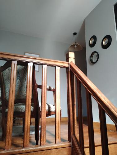 a wooden staircase with a wooden chair in a room at La Maison de Paulette in Viéville