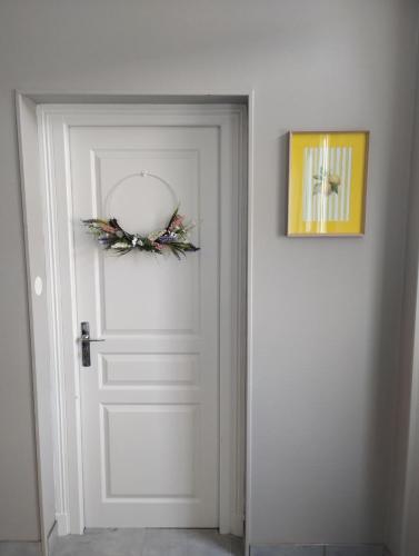 a white door with a wreath on it at La Maison de Paulette in Viéville