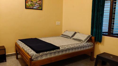 a small bed in a room with a window at Areca Nest in Gokarna