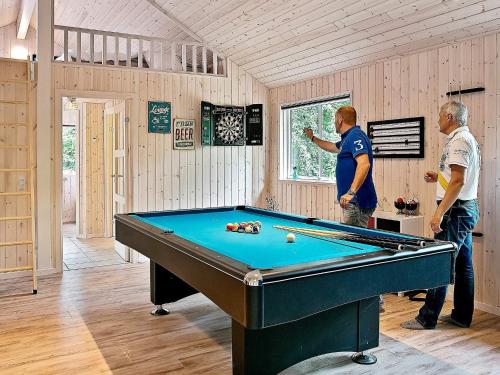 two men standing in a room with a pool table at Luxury Pool Villa in Dronningmolle - By Traum Ferienwohnungen in Gilleleje