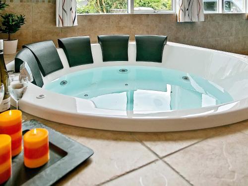 a bath tub with green chairs in a bathroom at Luxury Pool Villa in Dronningmolle - By Traum Ferienwohnungen in Gilleleje
