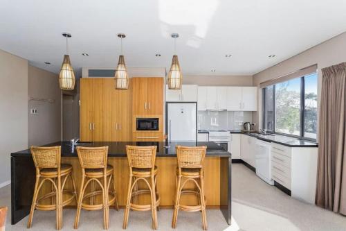 a kitchen with a wooden table and chairs at Dolphin Views in Burrill Lake