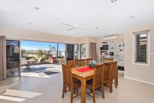 a dining room with a wooden table and chairs at Dolphin Views in Burrill Lake