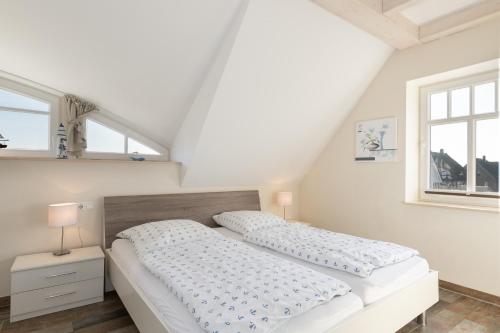 a bedroom with two beds and two windows at Haus Ostseestrand in Lancken
