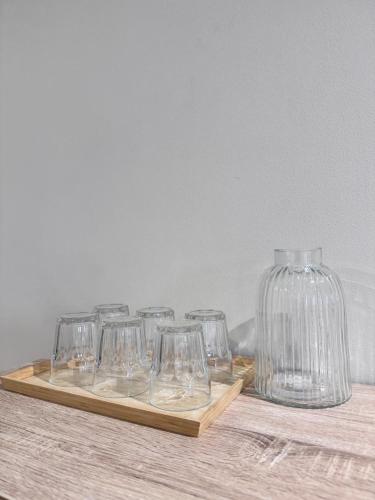 a group of wine glasses sitting on a wooden tray at Comfy Damansara PJ Condo 3BR 2Carpark in Petaling Jaya