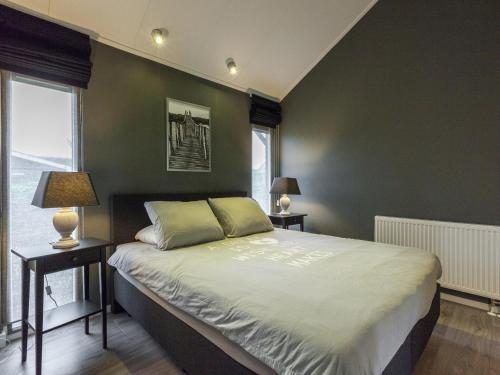 a bedroom with green walls and a bed with two lamps at Relaxing Home Close to Diving Spots in Kattendijke