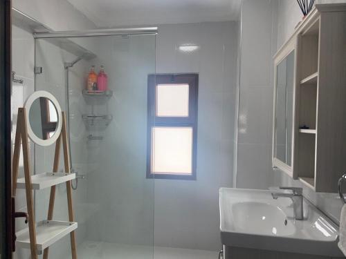 a bathroom with a glass shower and a sink at Mango Apartment Hotel 芒果公寓酒店 in Zanzibar City