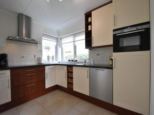 a kitchen with white cabinets and a large window at Family Home in Zeewolde by Forest Trails in Zeewolde