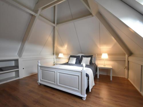 a bedroom with a white bed in an attic at Family Home in Zeewolde by Forest Trails in Zeewolde