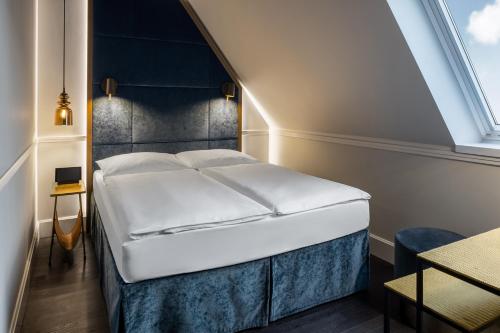 a bed in a room with a large window at Hotel AMO by AMANO Friedrichstraße in Berlin