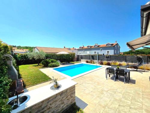 a backyard with a swimming pool and a house at Family house Hana in Kanfanar