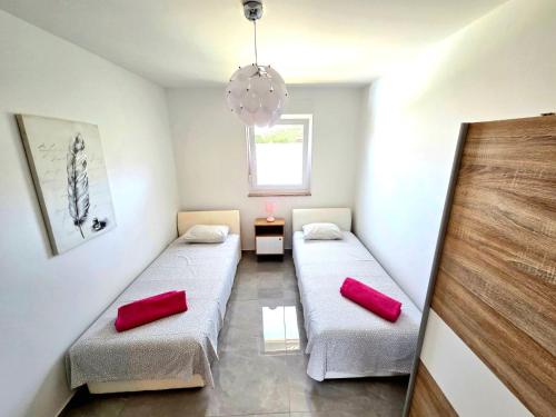two beds in a room with red pillows at Family house Hana in Kanfanar