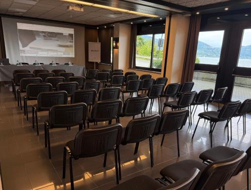 una sala de conferencias con sillas y una pantalla de proyección en Hotel Concorde, en Arona