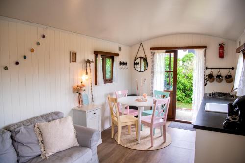 Una cocina y una sala de estar con mesa y sillas. en Pipowagen, en Serooskerke