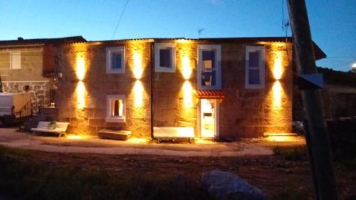 a house with lights on the front of it at Duplex en Ribeira Sacra in Sistín