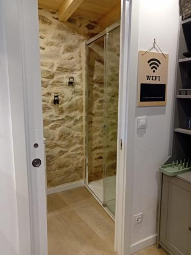 a shower with a glass door in a bathroom at Duplex en Ribeira Sacra in Sistín