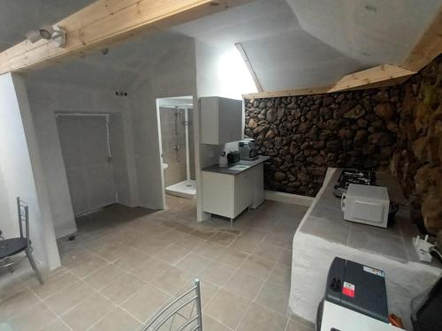 a kitchen with a stove and a stone wall at Ferienwohnung echt kanarisch mit Meer und Teide Blick La Vega Teneriffa Nord in Icod de los Vinos