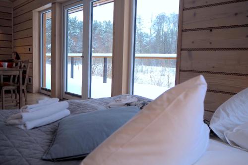 a bedroom with a bed with pillows and a window at 2os Domek z prywatną balią z jacuzzi, kominek, na odludziu, jedyny na 10000 m2 terenie, widok na las, lubelskie Roztocze in Oseredek