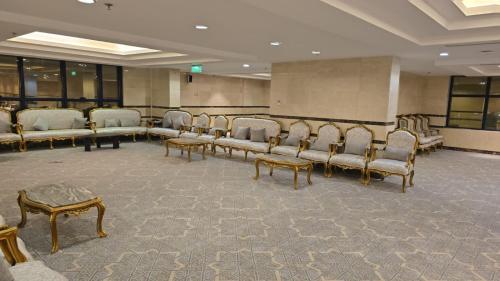 una sala de espera con un montón de sillas y mesas en فندق دفلى, en La Meca