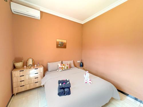 a small bedroom with a bed and a dresser at Évasion Douce avec jardin, terrasse et piscine privée in El Aggada
