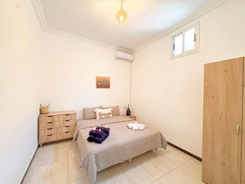 a bedroom with a bed and a dresser in it at Évasion Douce avec jardin, terrasse et piscine privée in El Aggada